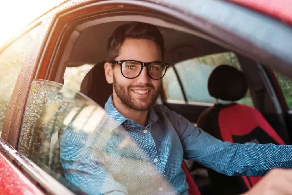 man with glasses driving